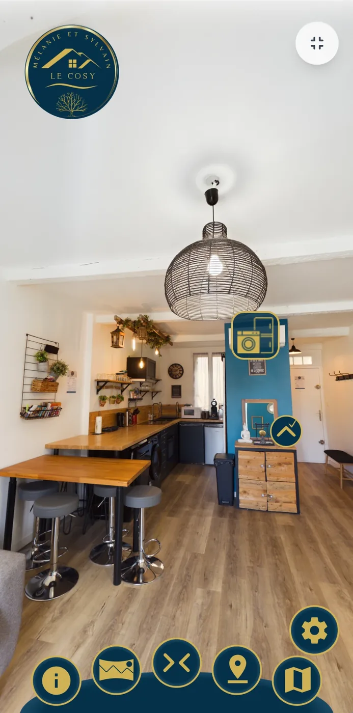 Visite immersive 360° de l’appartement Le Cosy : cuisine ouverte et mur bleu